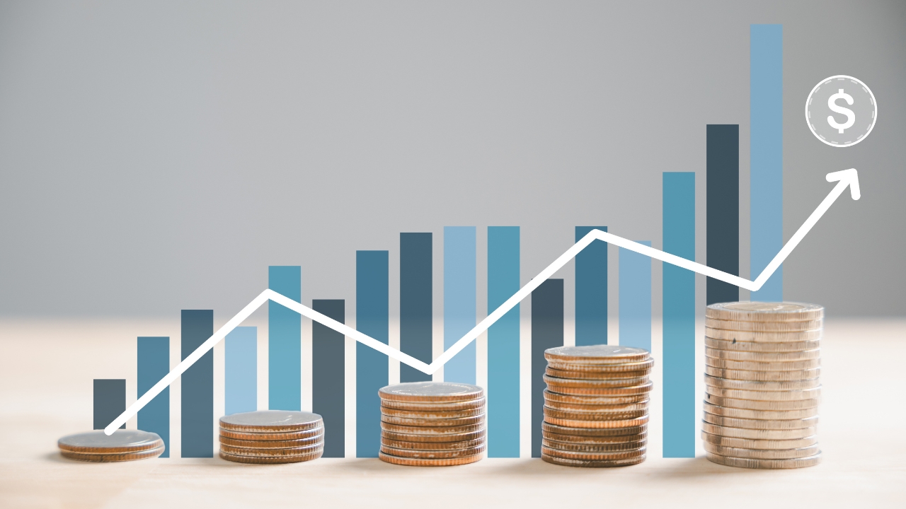 Stacks of coins rise alongside a bar chart and upward arrow showing profit growth