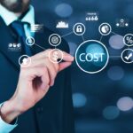 Businessman points at cost icons on screen, showing how basic maths shapes product pricing and profit